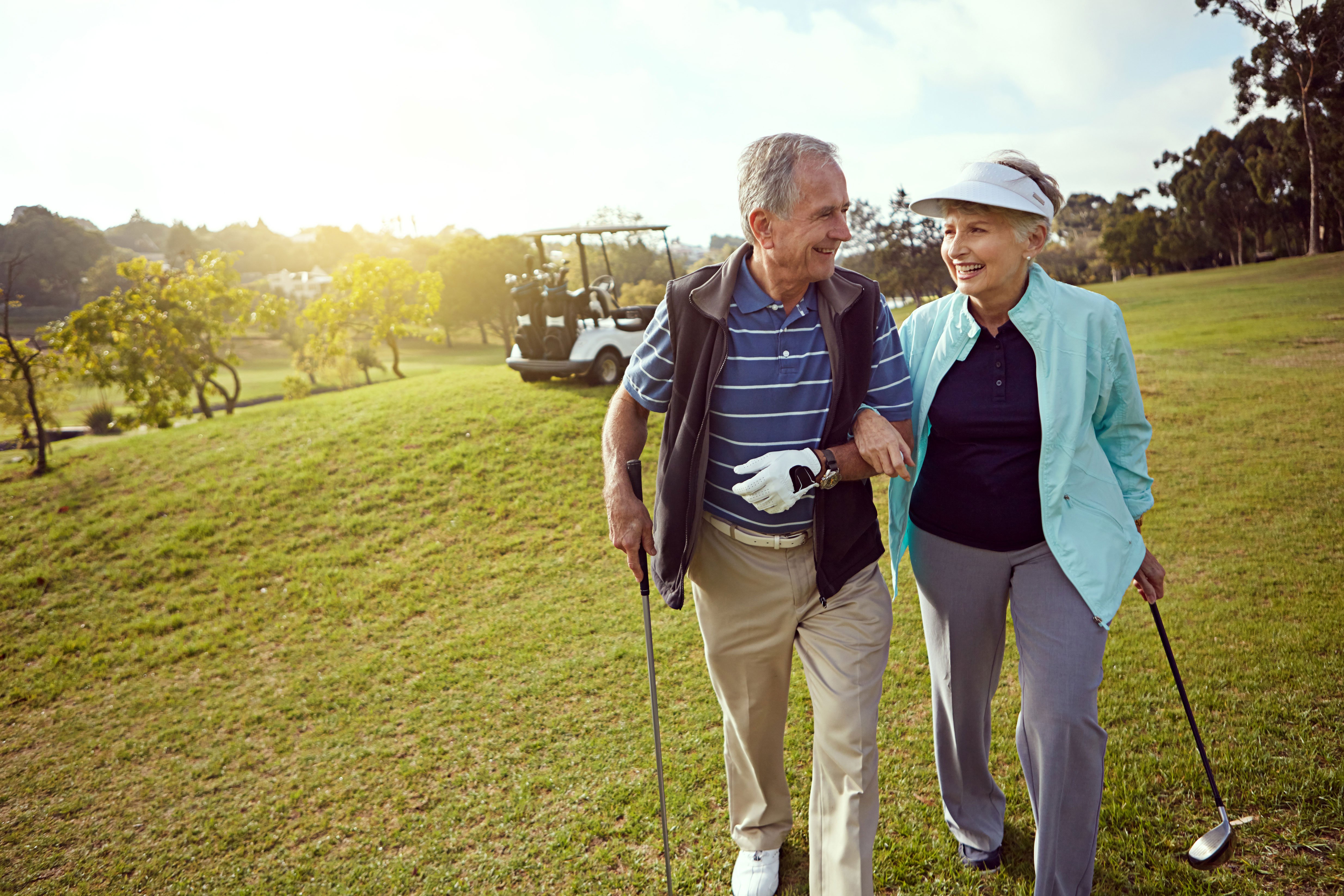 A happy senior couple enjoys an active day on the golf course